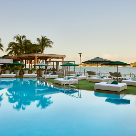 piscina hermosa con tumbonas lujosas y sombrillas a su alrededor. Con vistas a la bahía