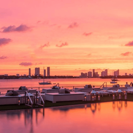 puesta de sol colorida sobre la piscina y la bahía