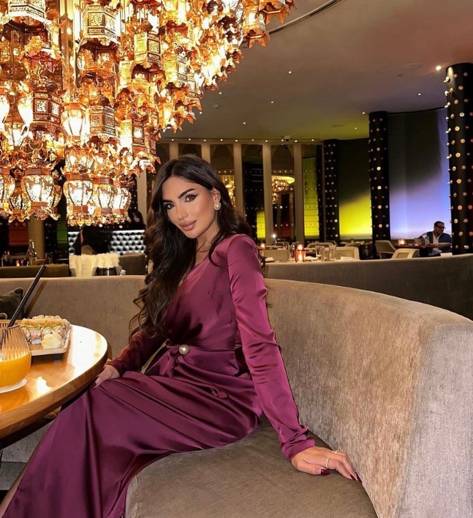 Mujer con vestido largo morado sentada en el Mondrian Doha