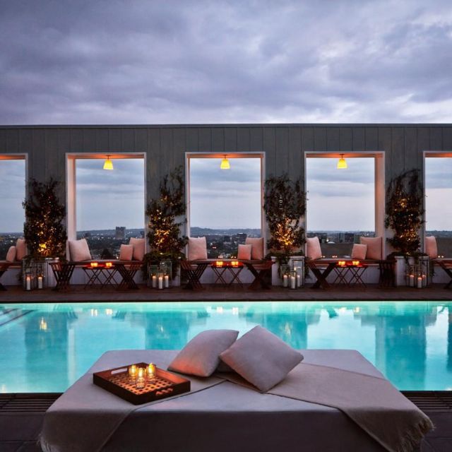 Skybar Los Angeles at night with a pool and daybeds with candles