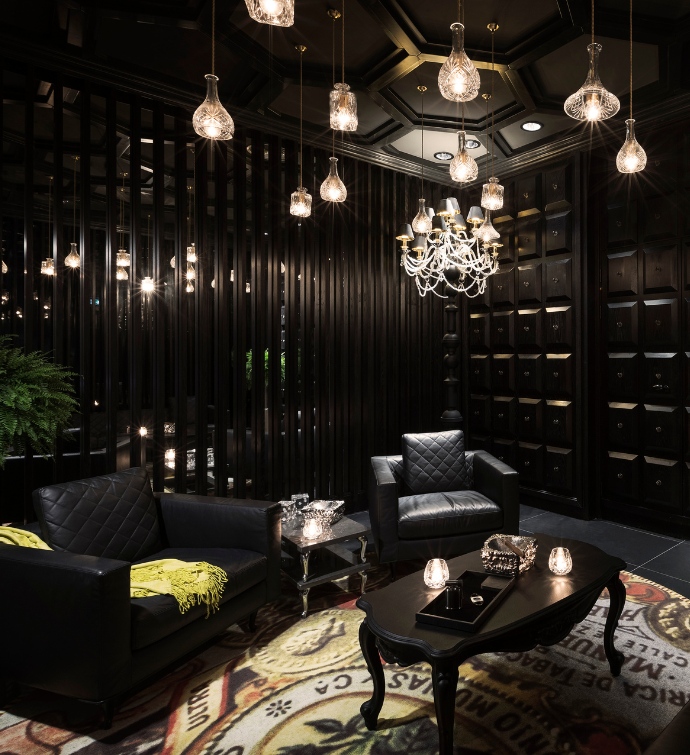 Interior of Smoke & Mirrors Doha with hanging lights and large leather chairs