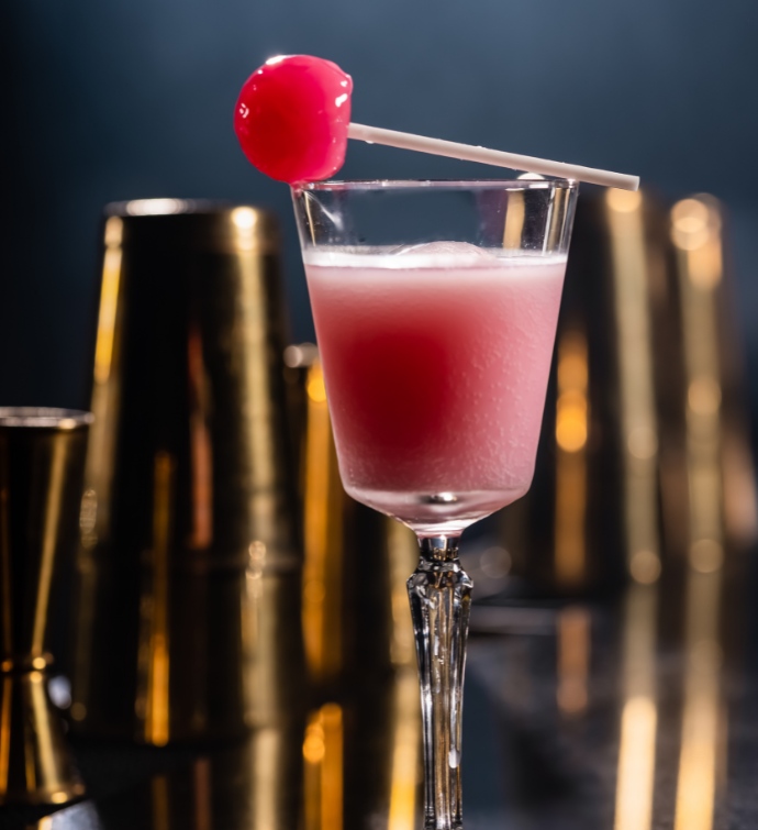 Cocktail glacé rose avec une sucette sur le dessus au Smoke & Mirrors Doha