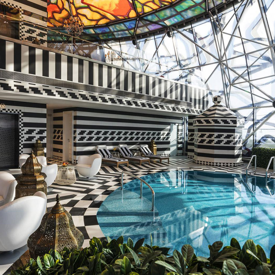 Mondrian Doha spa round pool with black and white floors and walls, and a stained glass ceiling.