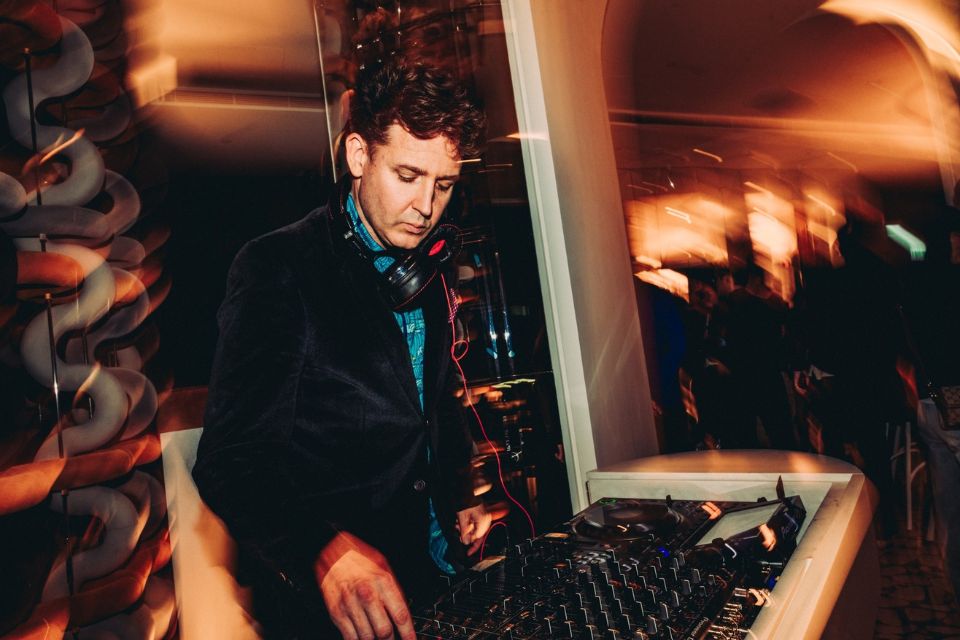 Male DJ spinning the decks with a blurry background