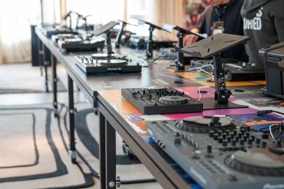 Multiple sets of DJ equipment on black tables