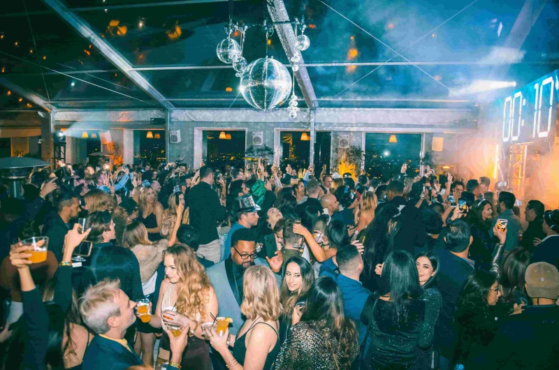 People gathered in a club like setting with a disco ball