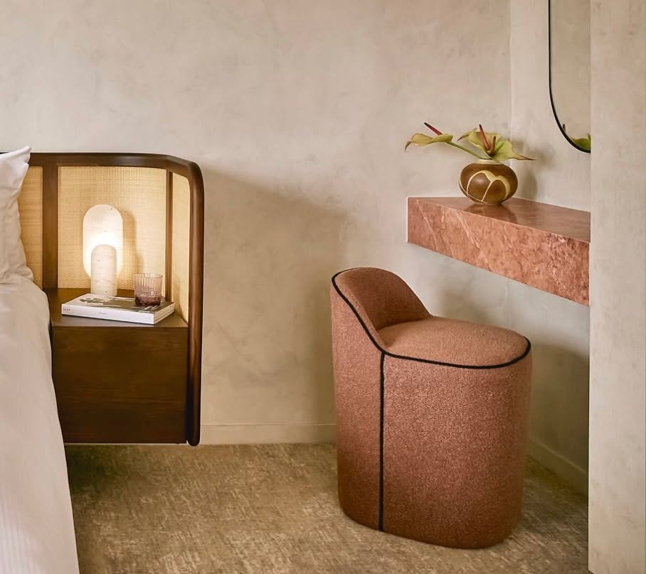 Side of bed and pink vanity chair with marble pink countertop