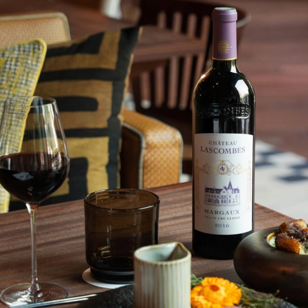 Bottle of red wine and glass of red wine on table