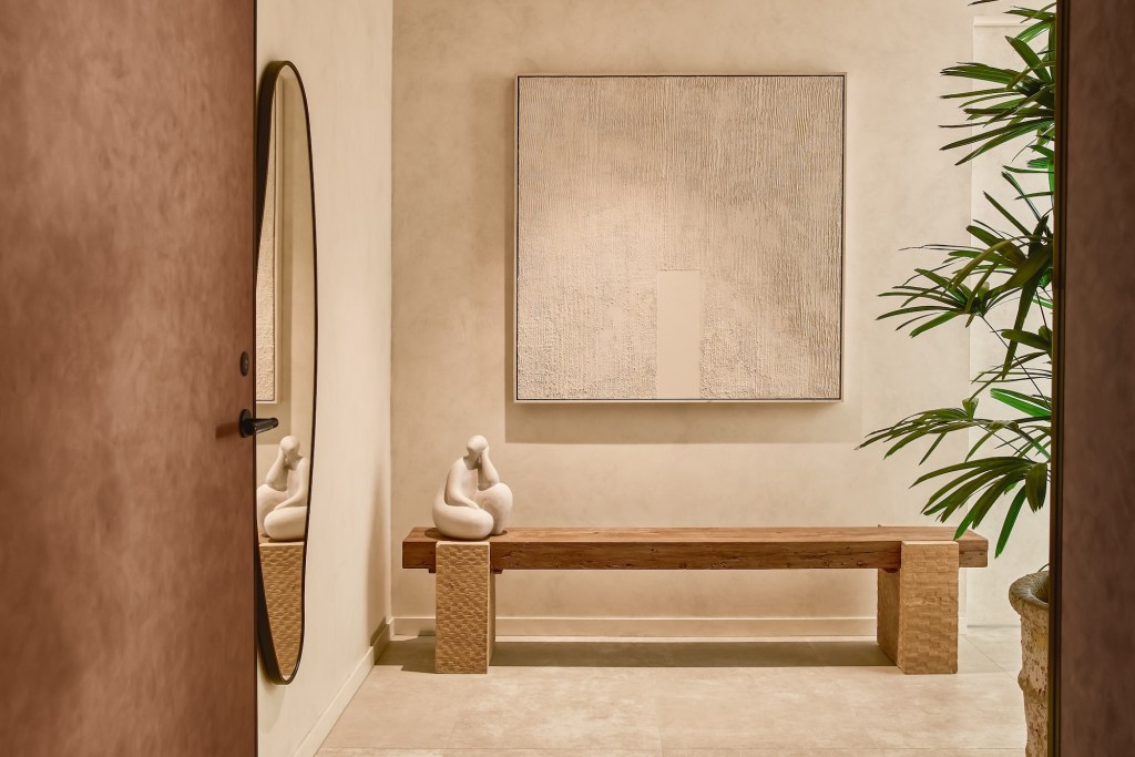 Light wooden bench in a cream colored entryway