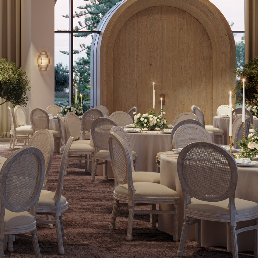 Close up image of ballroom round tables with white tablecloths and white chairs