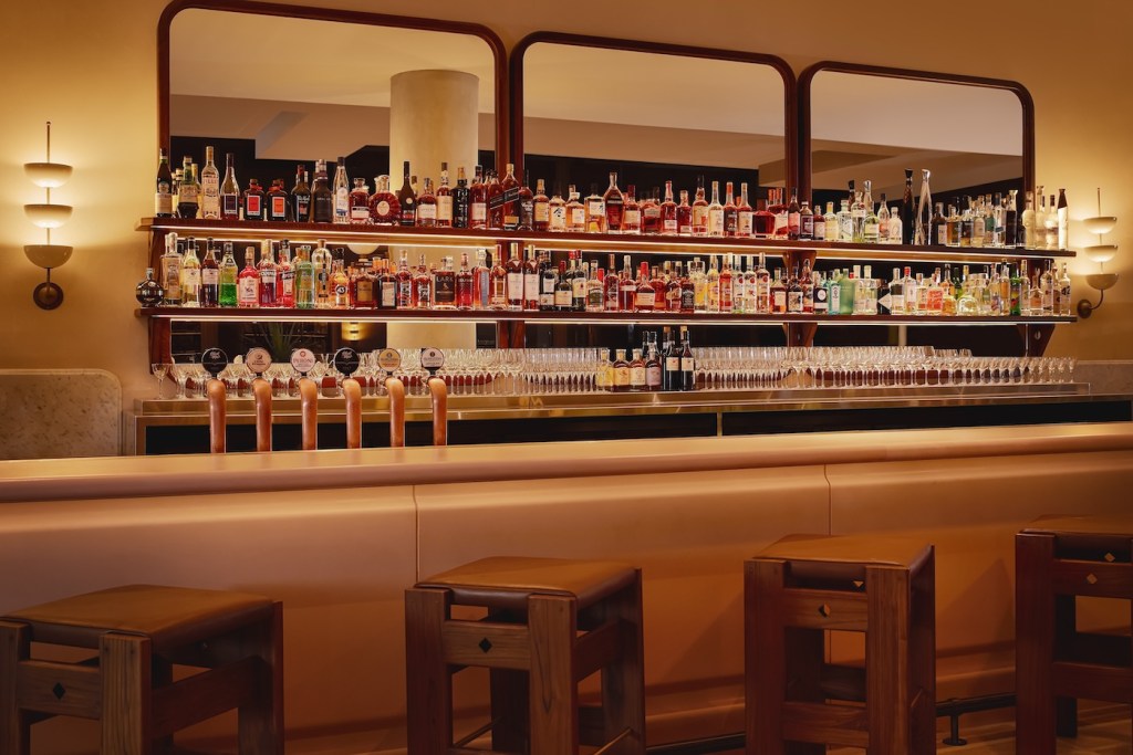 Warmly lit bar with shelves of bottles of liquor