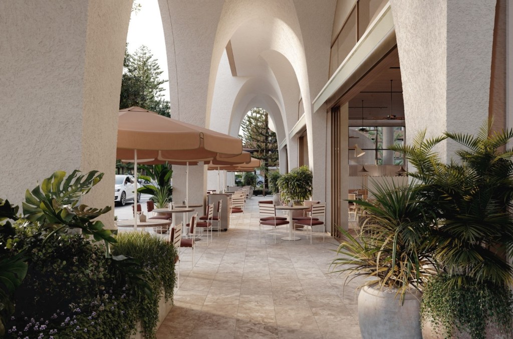 Outdoor restaurant hallway with curved, structural walls, beige awnings over small outdoor tables and chairs