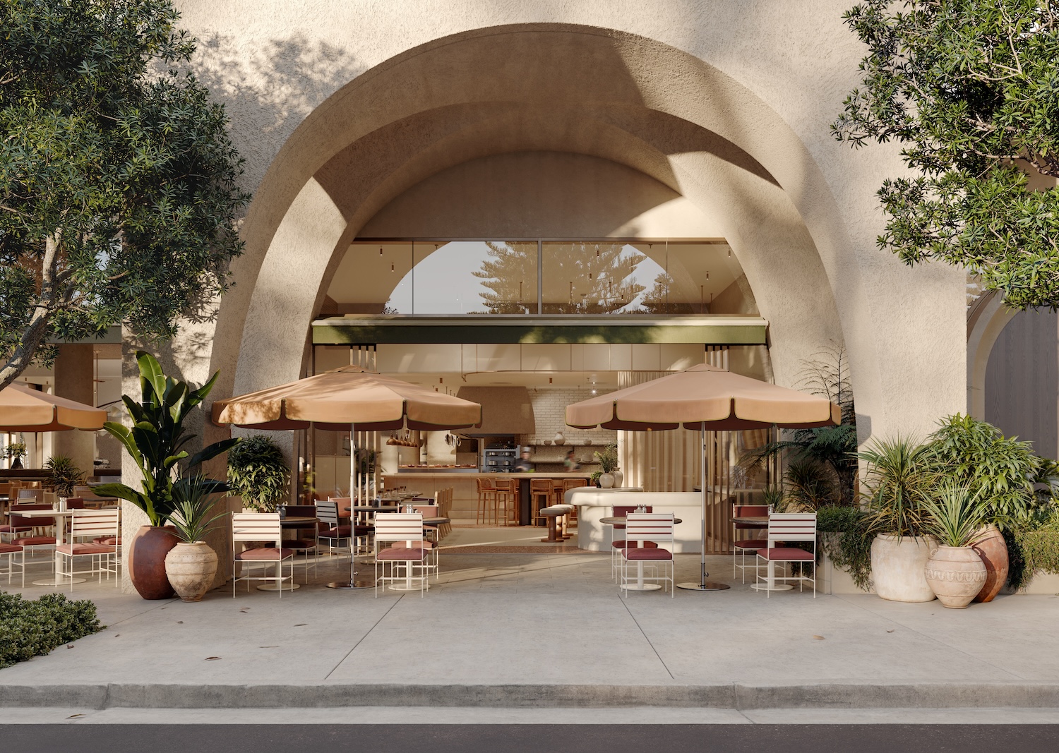 Outdoor cafe with umbrellas, tables, and chairs under cream building arches