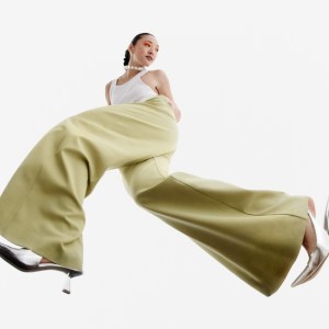 Woman posing in flared yellow plants and silver heels