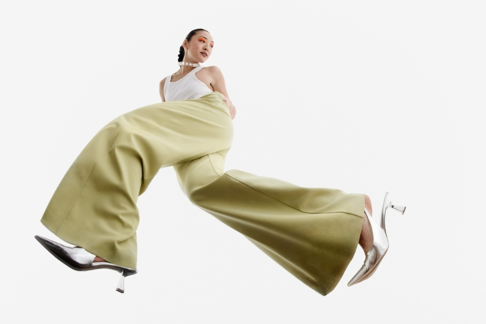 Woman posing in flared yellow plants and silver heels