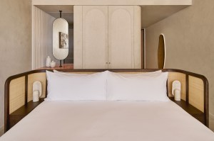 Large white bed with beige and dark wood headboard