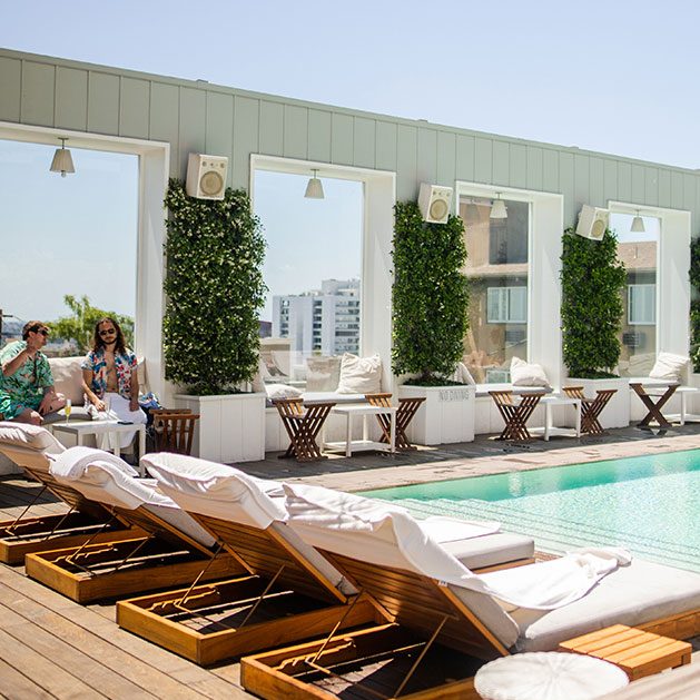 Skybar LA rooftop pool at Mondrian Los Angeles, with daybeds and windows with views of the city.