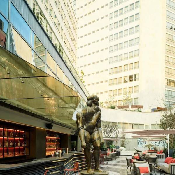 Large dark statue of a man outside of a modern building