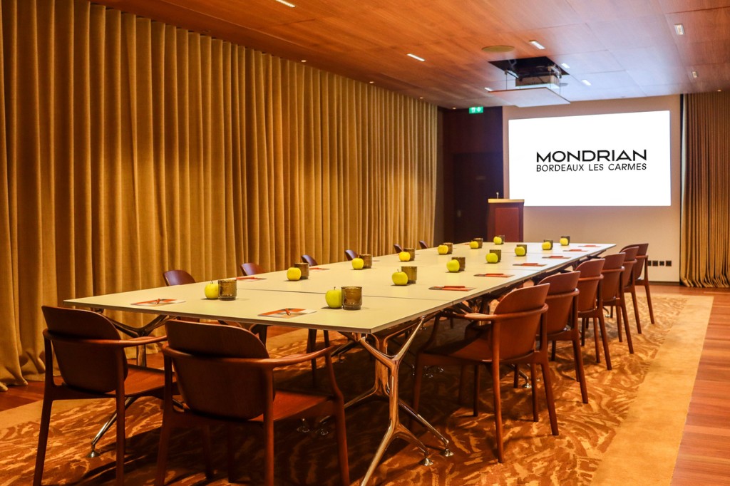Large board room table with chairs and a screen