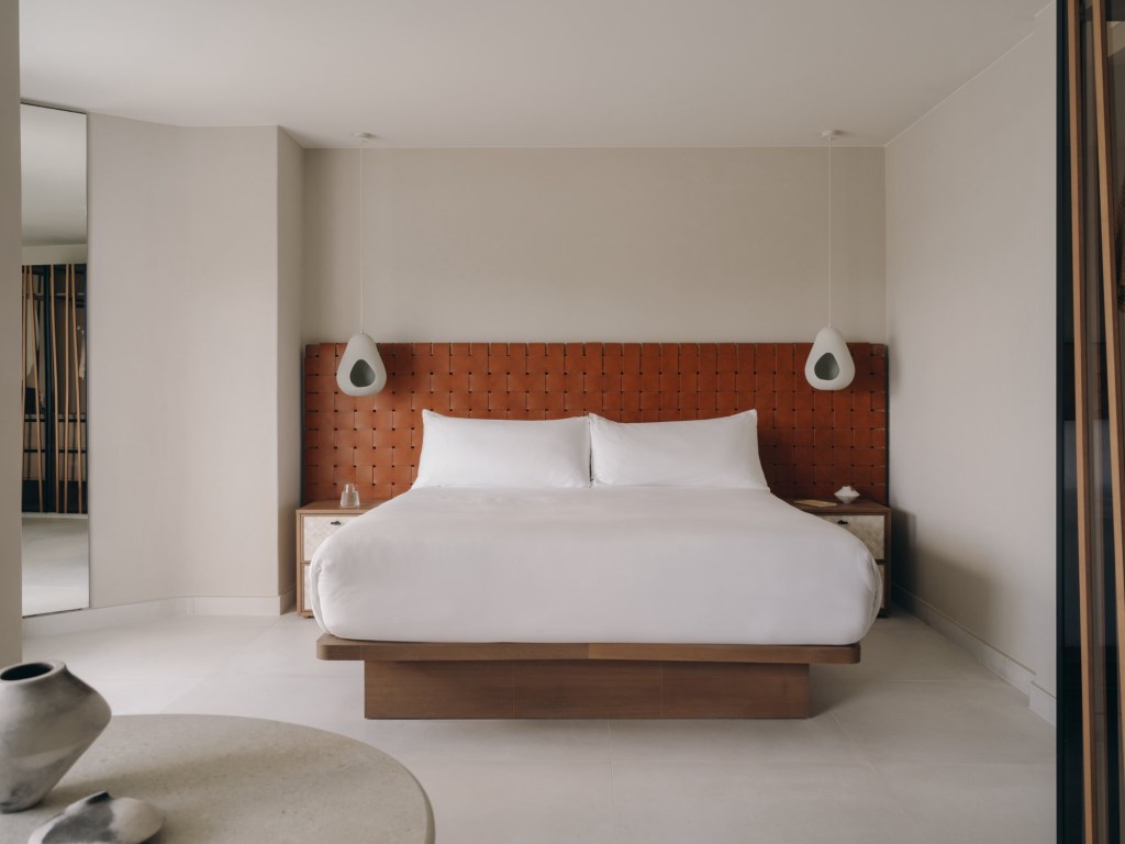 Good - Mondrian Ibiza Studio Suite Large white bed with chestnut brown weaved headboard and white hanging lights on either side of the bed