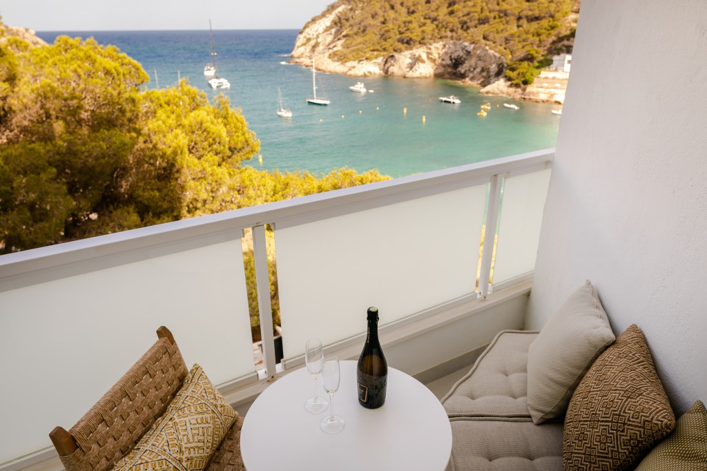 Good Mondrian Ibiza One Bedroom Suite Sea View, balcony with a chair, table and seating area looking to the Mediterranean Sea