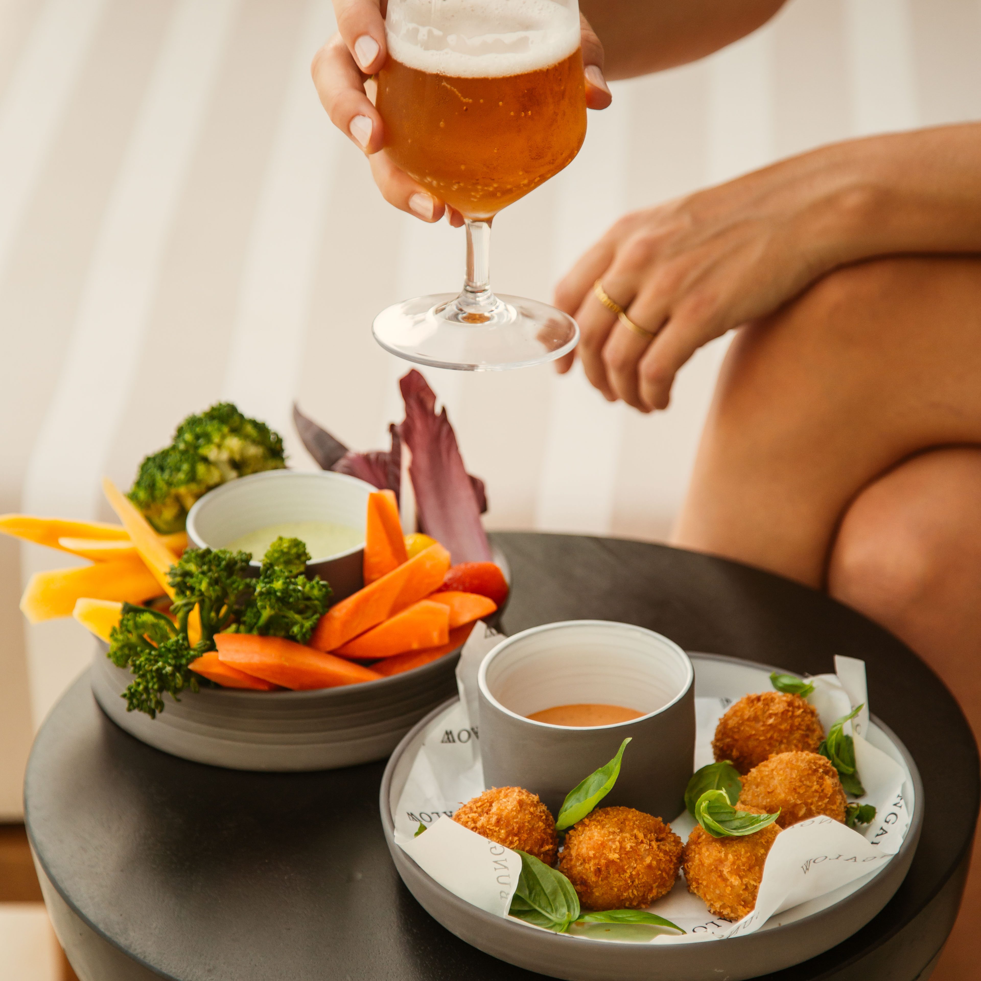 Healthy bites croquettes and raw vegetables accompanied by a fresh cold beer