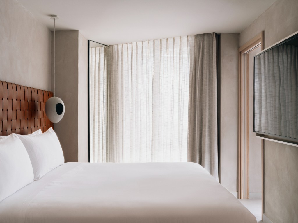 Good Mondrian Ibiza One Bedroom Suite Sea View, Side of white bed with rust colored headboard and curtains covering a balcony window