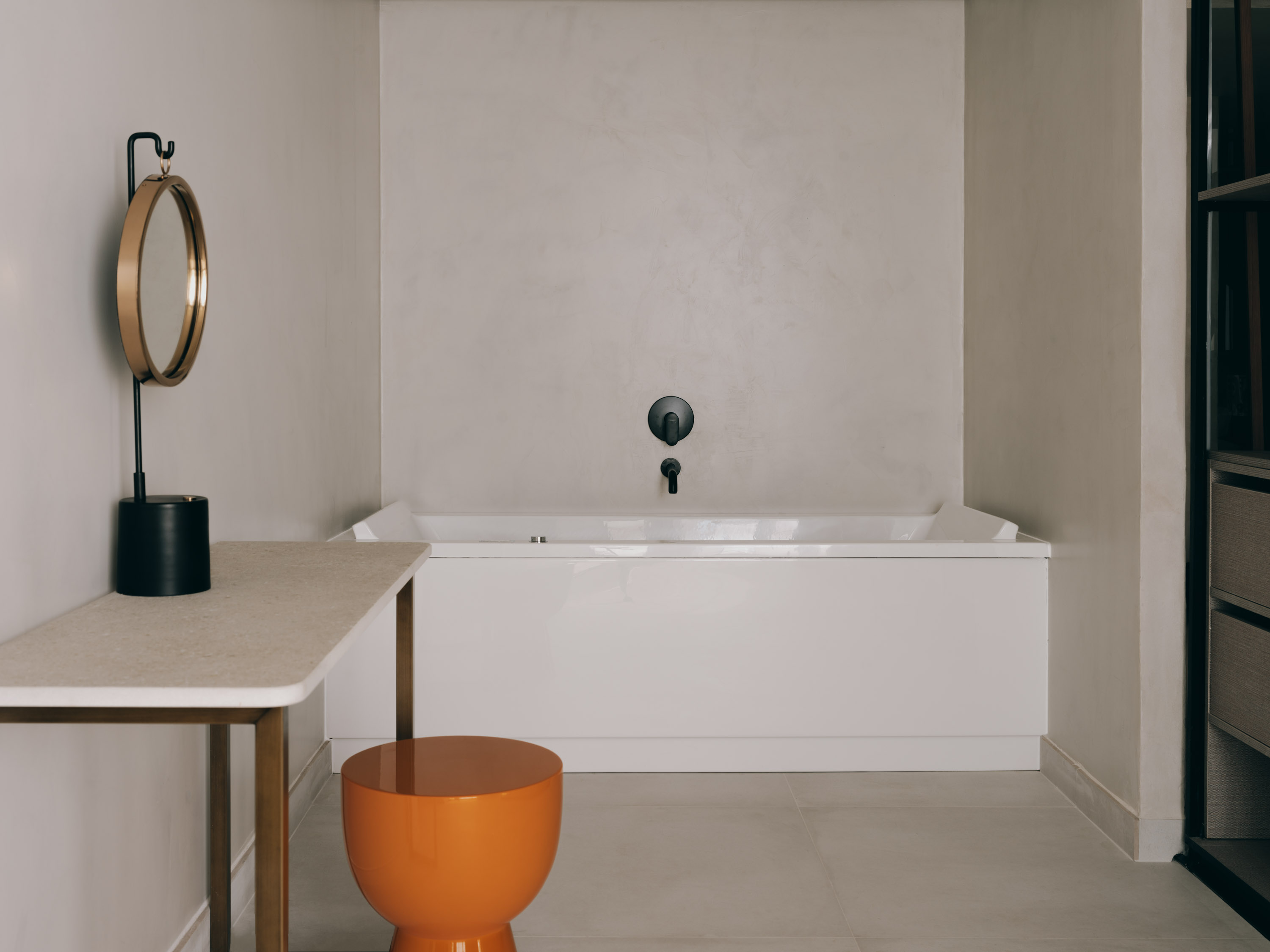 Mondrian Ibiza Presidential suite - build in bathtub inside of the dressing room with a vanity, a stool and a mirror.