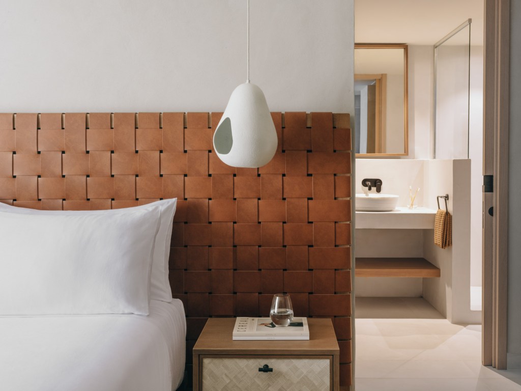 Good - Mondrian Ibiza Hotel - Deluxe King room, a neatly made bed with crisp white sheets and a sleek white lamp on a bedside table.