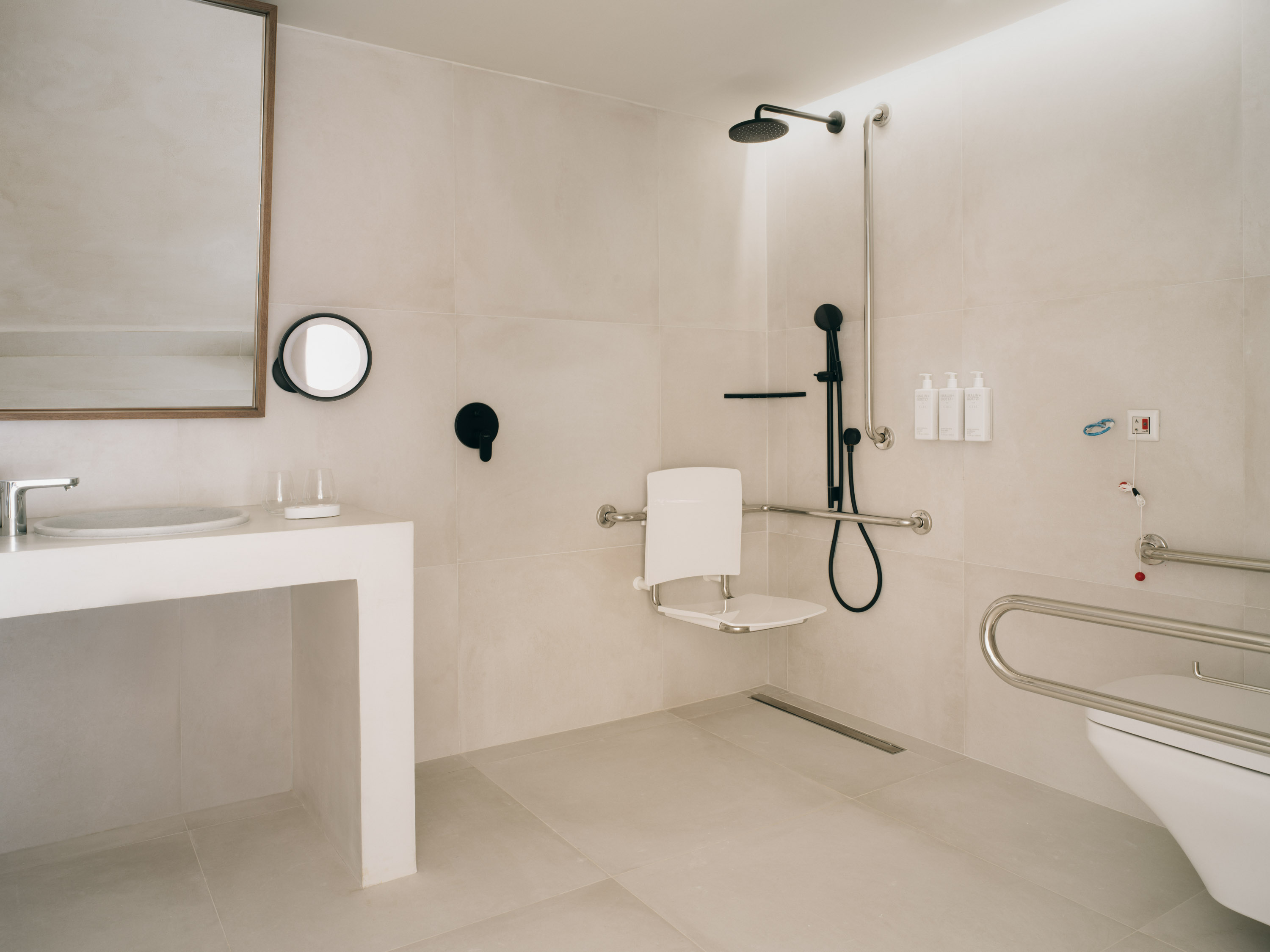 Mondrian Ibiza Deluxe King Accessible Room. An accessible by wheelchair modern bathroom with a waterfall shower.