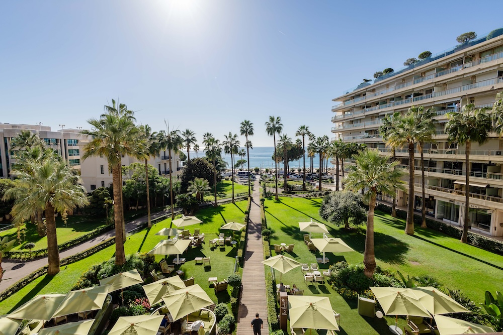 Beautiful garden area with tables and chairs and palm trees surrounding