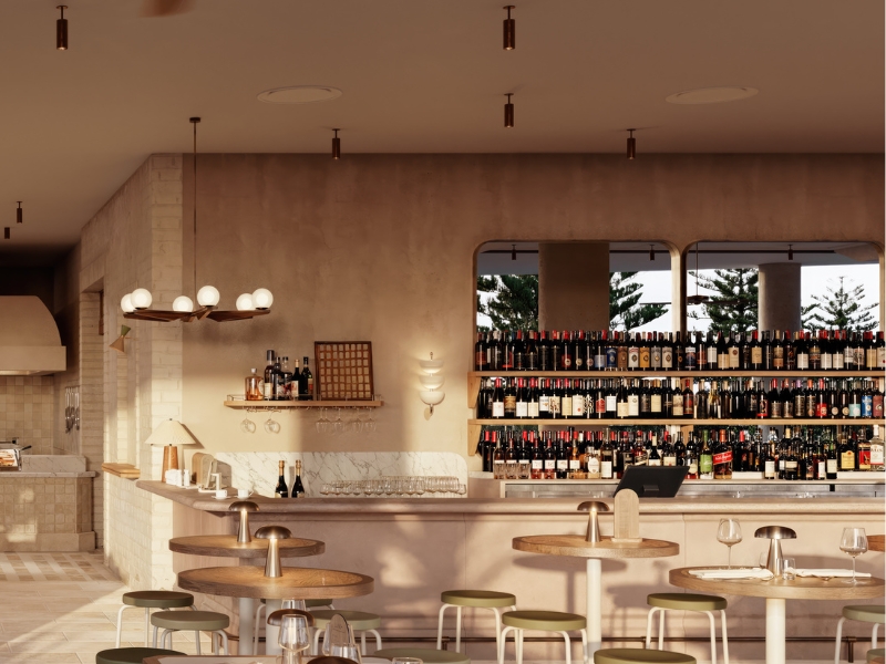 Sunlit bar with extensive bottles lined up with modern bar furniture