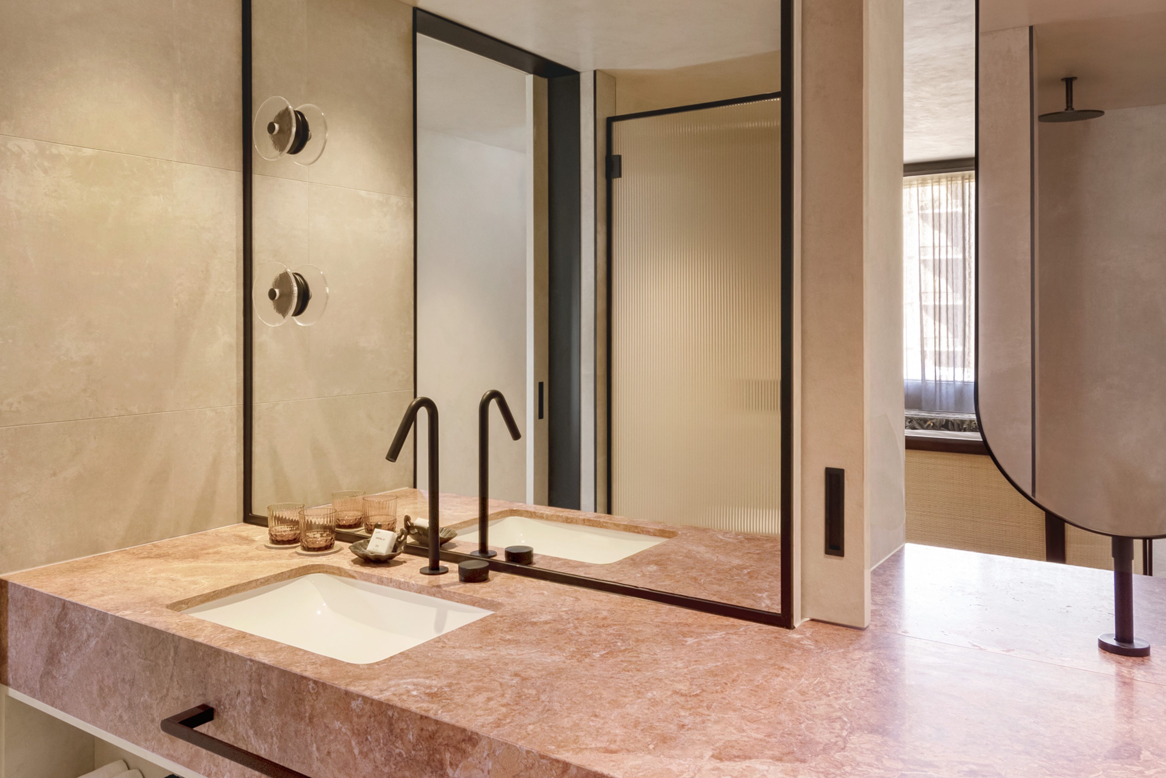 Bathroom sink with pink marble countertop and multiple mirrors