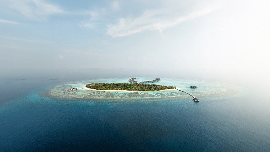 Rows of villas and an island floating on a blue ocean