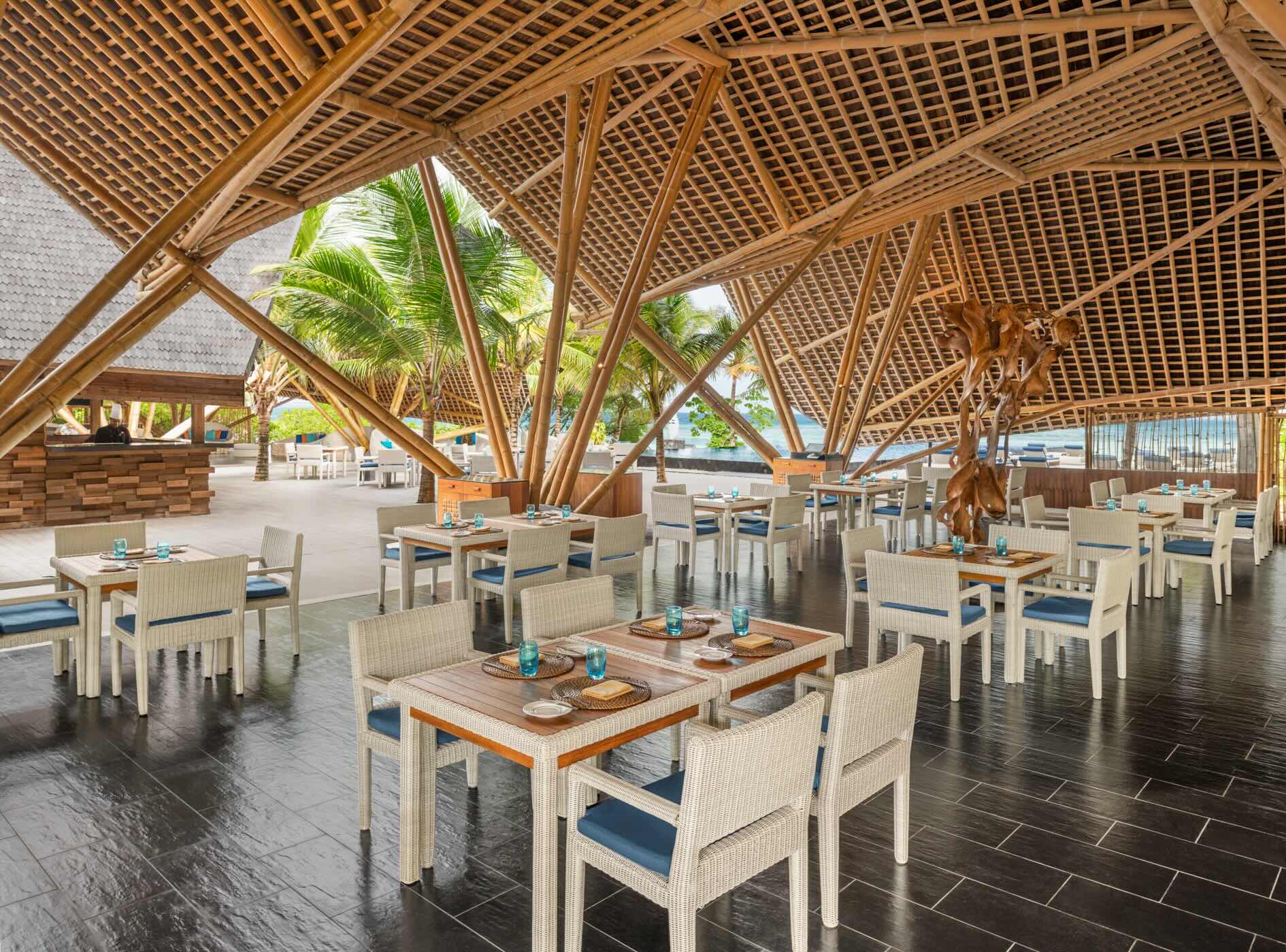 Outdoor covered dining area with multiple small tables and chairs