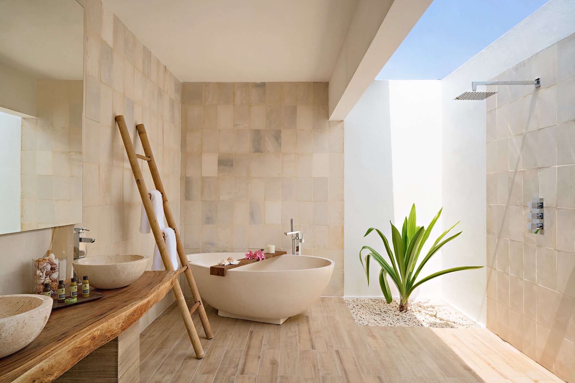 Large bathtub in the middle of a cream indoor/outdoor bathroom