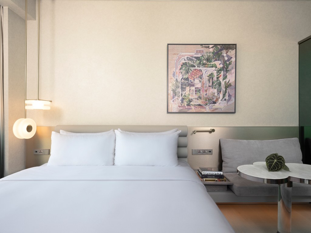 hotel room showing kind bed and a side table in Mondrian Singapore Duxton