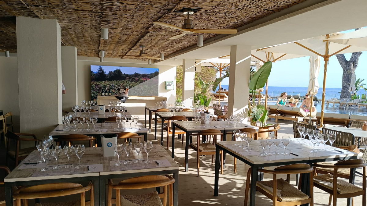 Outdoor tables covered by patio with Wine glasses set up for a wine tasting