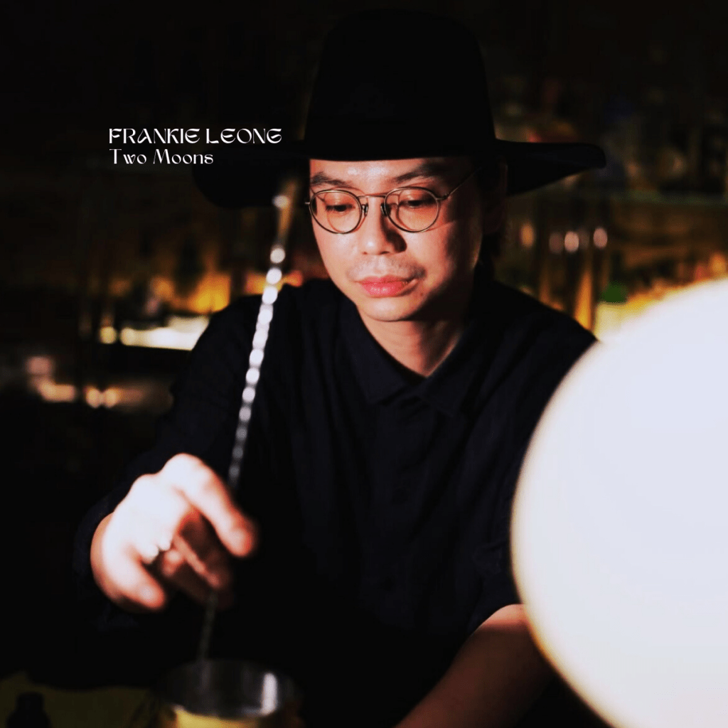 bartender stirring a drink in a dark space