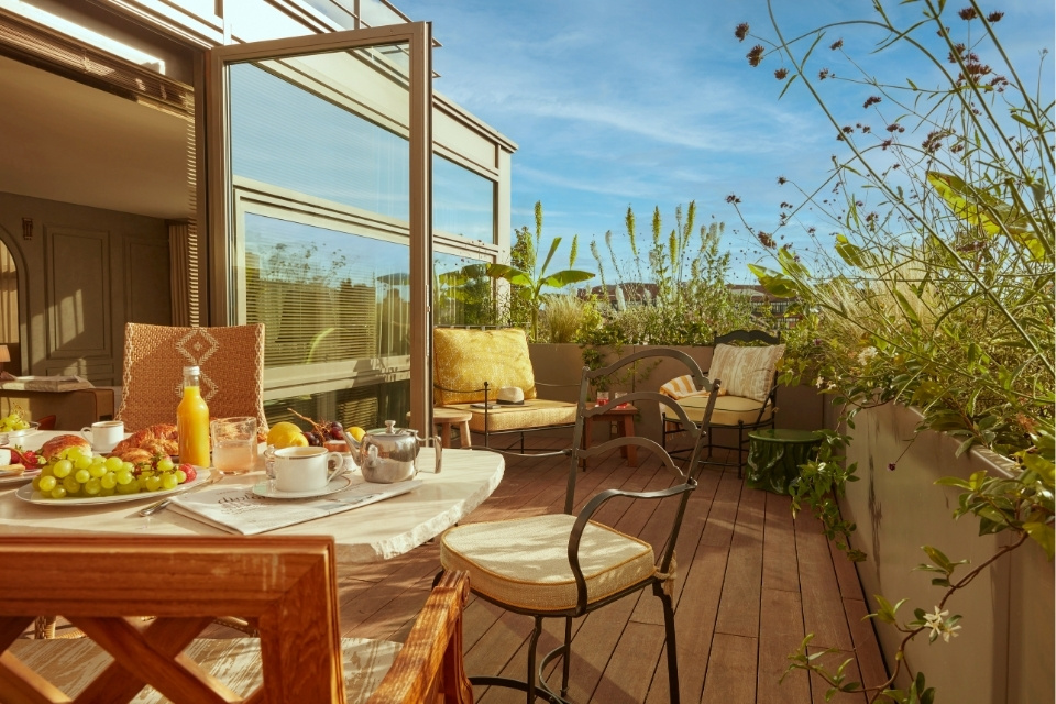 Beautiful outdoor terrace with greenery, outdoor chairs, and tables