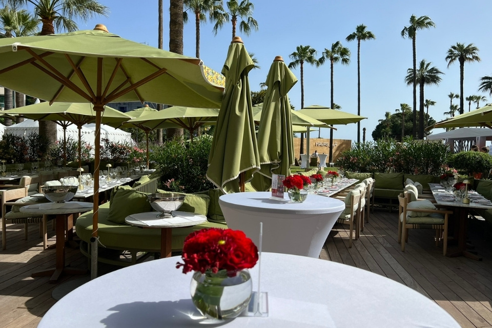 Round white tables outside with red roses on top