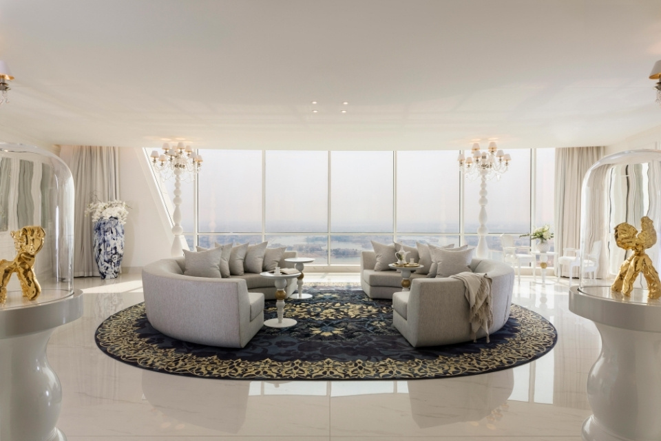 Two grey, curved sofas in a white penthouse room