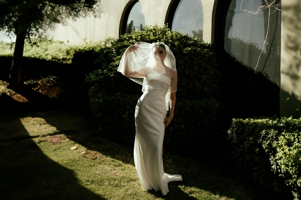 Woman in white wedding dress and veil outside
