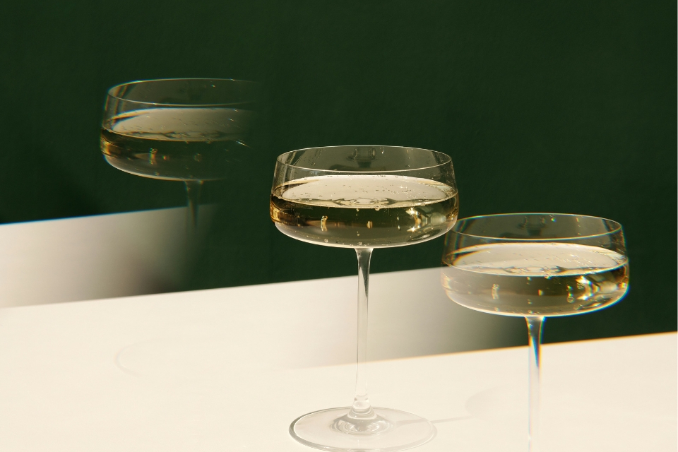 Three champagne glasses on a white surface