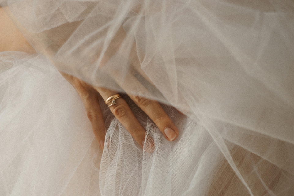 Close up image of white tulle fabric and a woman's hand