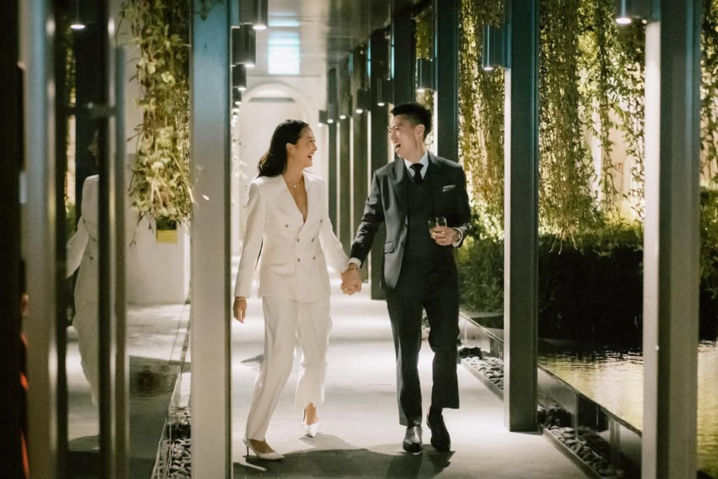 couple happily running through a green corridor
