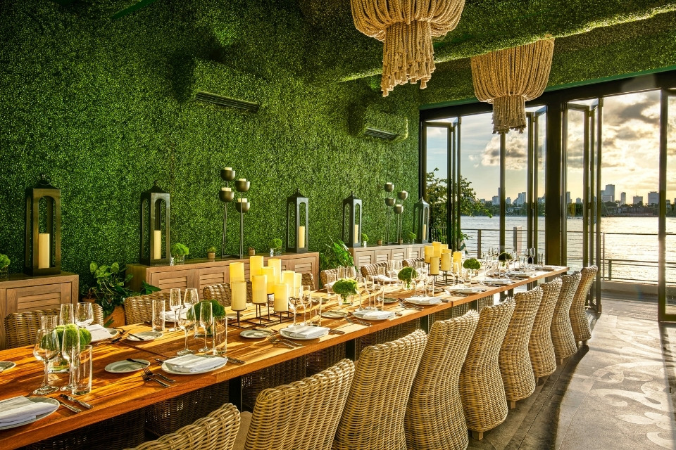 Large rectangle table with woven chairs and greenery wall