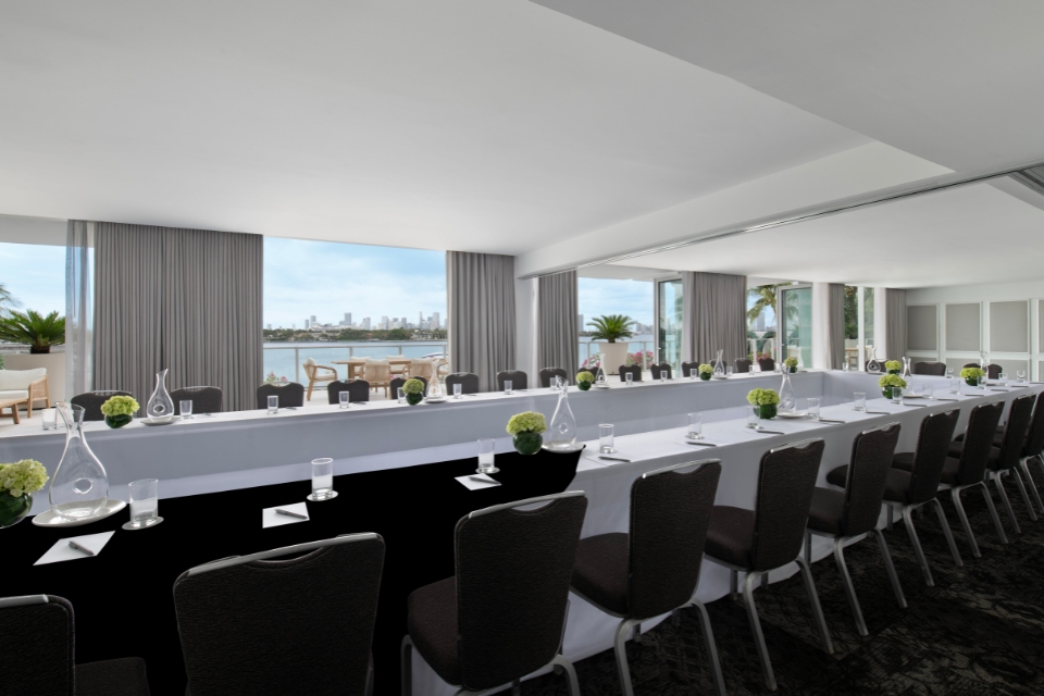 Large white table set up for a business meeting