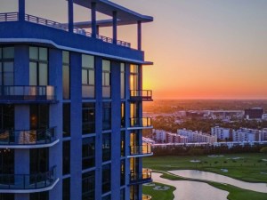 High rise building overlooking a golf course at sunset