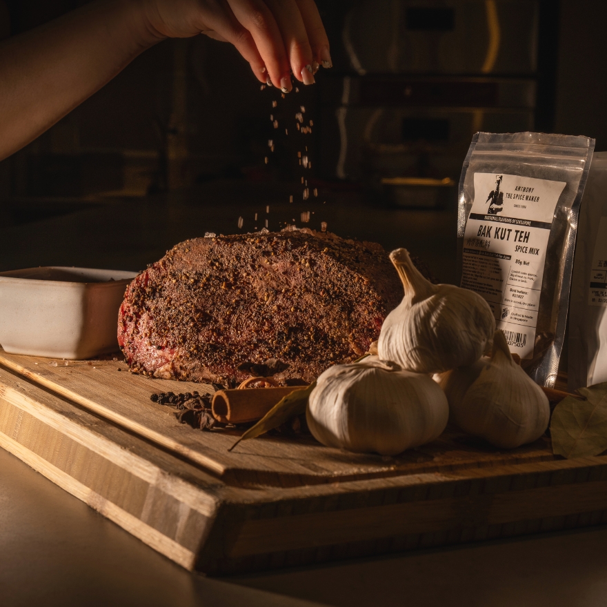 Piece of beef with hand sprinkling salt overtop it